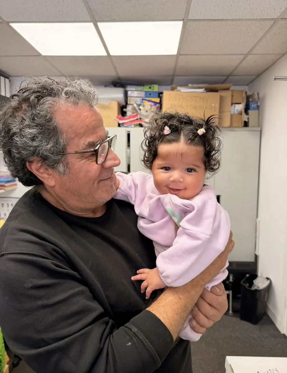 Andy, the proprietor, holding his granddaughter at White Rose Motors