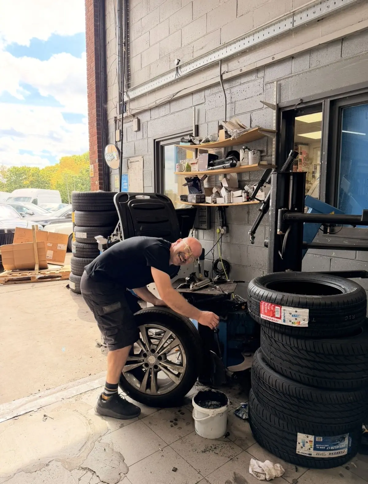 A White Rose Motors mechanic changing a tyre outside the workshop